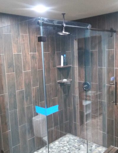 Dark Brown Themed Bathroom With Pivot Frameless Shower Door